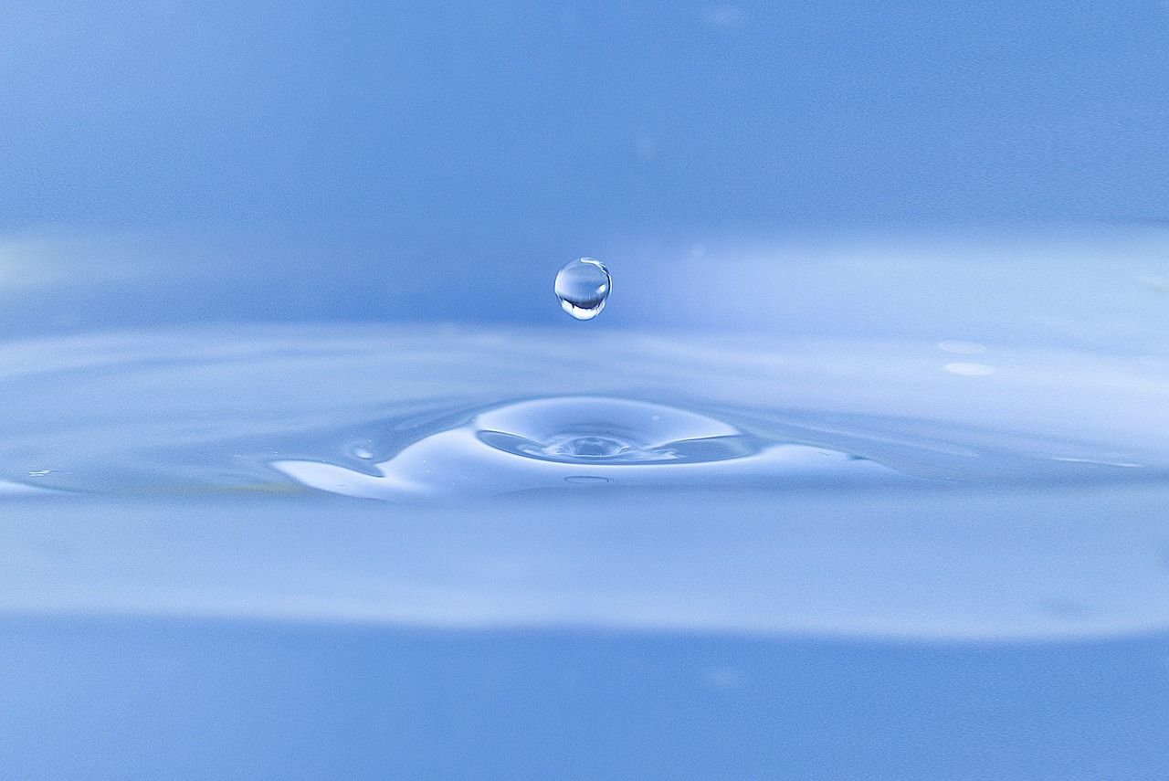 Gota de agua impactando en una superficie, simbolizando la eficiencia hídrica en el diseño sostenible de viviendas.