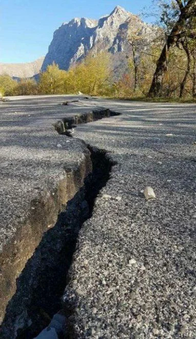 Gran grieta en una carretera tras un terremoto en España, mostrando los efectos de la actividad sísmica en infraestructuras urbanas y viales.
