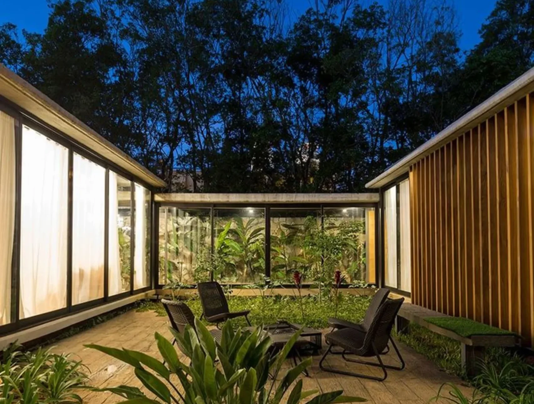 blog arquitectos 1 Patio interior biofílico en una residencia de lujo con vegetación integrada, madera natural y conexión visual con la naturaleza.