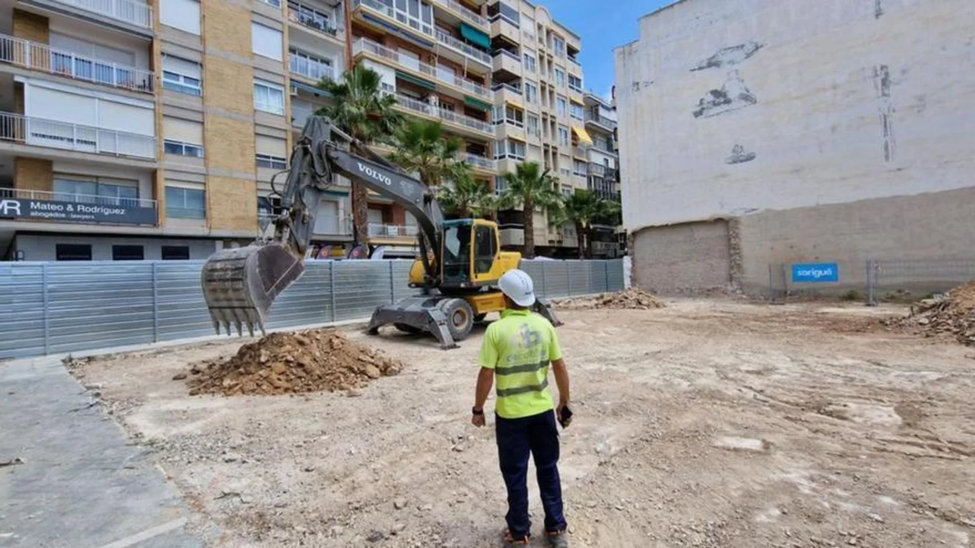 Excavadora trabajando en un solar urbano tras aprobación de licencia de obra mayor 