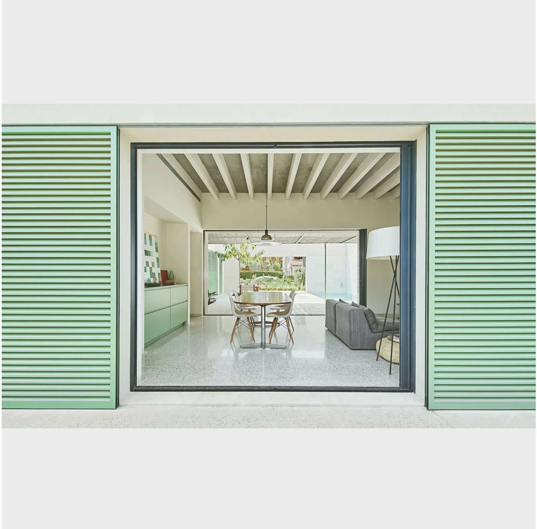 Patio mediterráneo moderno con comedor exterior y piscina en vivienda bioclimática de Mallorca