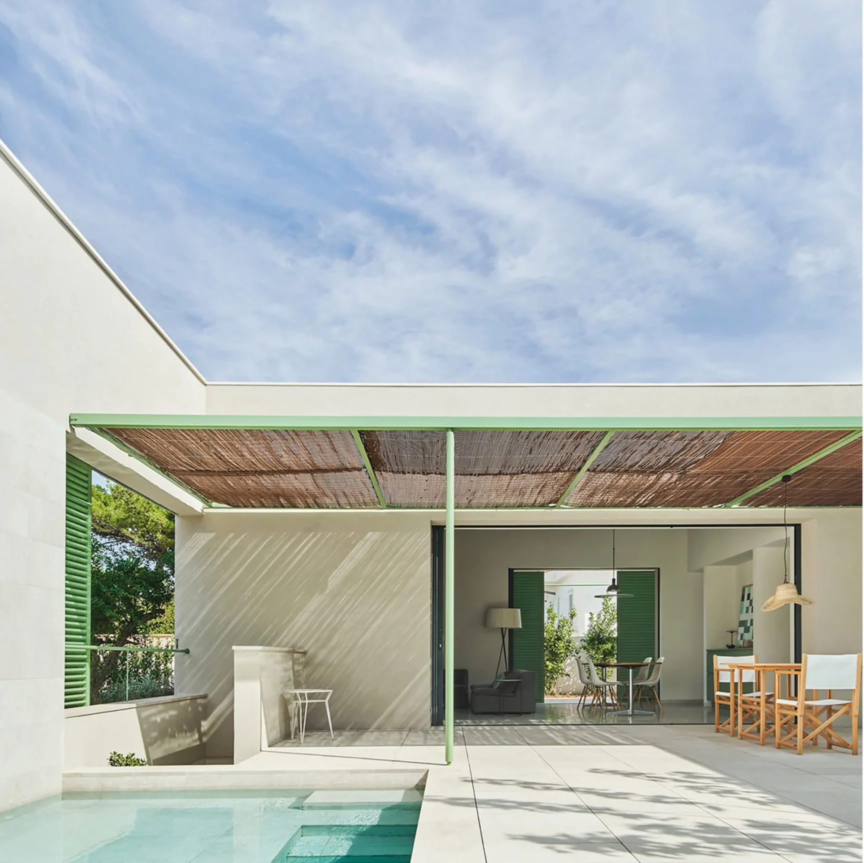 Interior luminoso con apertura directa a patio mediterráneo moderno y ventilación cruzada