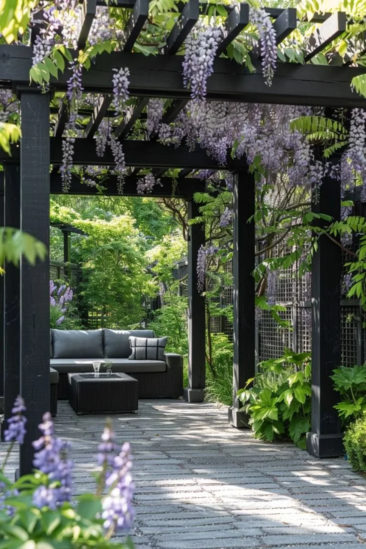 Pérgola negra con glicinias y zona de estar en un patio mediterráneo moderno