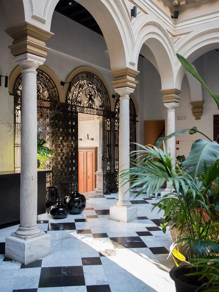 Patio central del Hotel Palacio de Villapanés en Sevilla con columnas y forja, muestra de rehabilitación de viviendas históricas