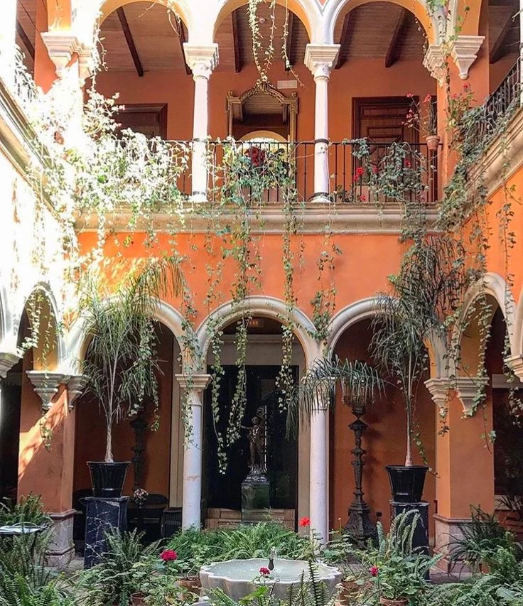Rehabilitación de Viviendas Históricas: El Arte de Transformar el Patrimonio Arquitectónico en Residencias de Lujo 3 Rehabilitación de viviendas históricas con patio sevillano tradicional de columnas y vegetación.
