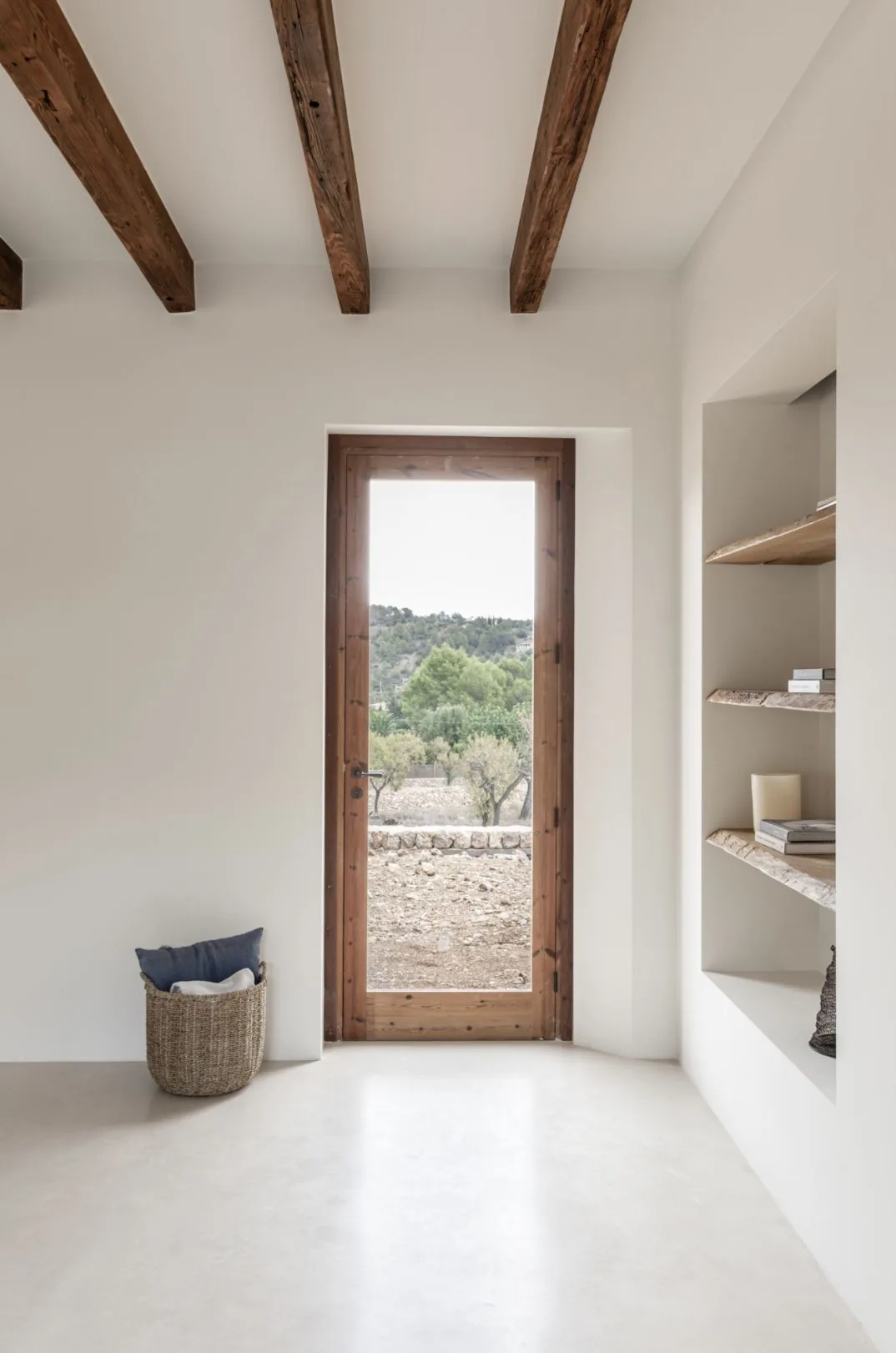 Interior minimalista con vigas de madera y vistas rurales.